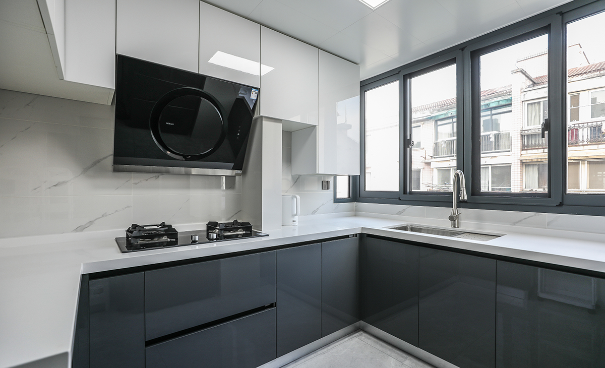 該套房子廚房空間很大，L型兩面櫥柜，另外冰箱邊上也有操作臺，顏色簡潔明快，材質要干凈和好打理，白色的吊頂和米色的櫥柜相呼應，各種廚房電器全部。