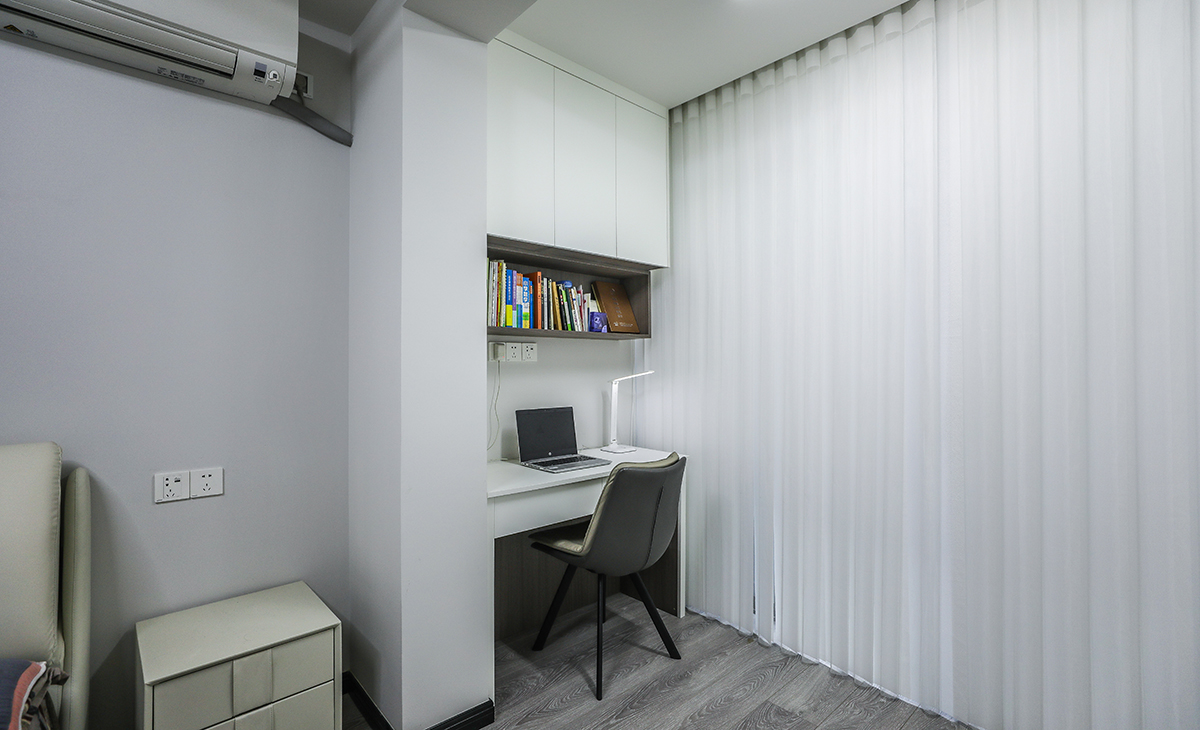 陽臺是主人的辦公場所，寫字臺及吊柜的組合，顏色以白色為主，儲物柜白色門板和黑色角線相搭配，配備白色一席紗簾若影若現，很舒適、很愜意。
