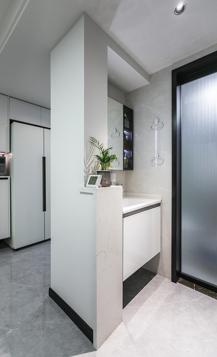 衛生間采用了干濕分離布局，臺盆做了90公分壁掛洗手臺及鏡柜，既滿足了客戶的儲物空間也增添了美感，滿足了早高峰上廁所和洗漱的同時需求。半高墻的大理石臺面也更體現主人高檔次的生活品味和優雅的審美觀。