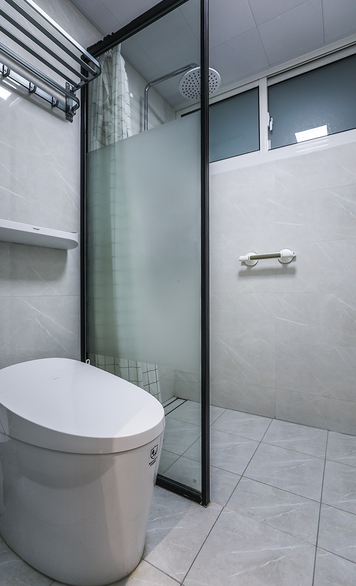 濕區，只放一個馬桶和淋浴區域，黑色邊框鋼化玻璃屏風隔斷，讓整個空間協調統一，大氣時尚，主人很滿意，不斷地夸贊設計師對色彩的精準把握。
