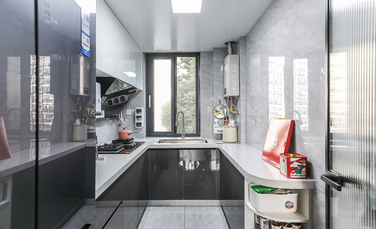 此廚房室U型設(shè)計(jì)，水槽、切菜，烹飪、等都沿著一條直線或直角排列，這樣的布局既方便了操作，也節(jié)省了空間。色調(diào)以黑白為主，線條簡(jiǎn)潔，沒(méi)有過(guò)多的裝飾，看起來(lái)非常干凈利落這樣的布局既實(shí)用又美觀。