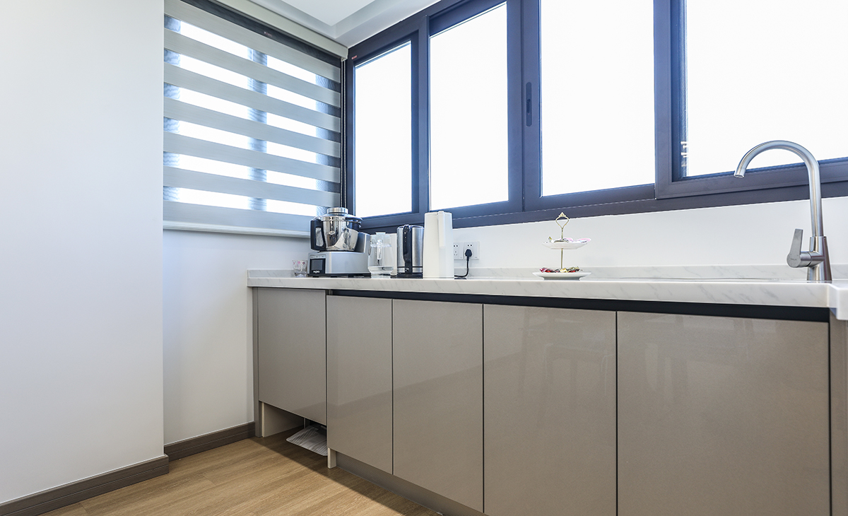 利用北陽臺空間做一排西櫥操作臺，臺面上放咖啡機，燒水壺、另外還有小水池，洗水果不用到廚房，方便實用，柜體內還能儲物，是間漏空一格可放掃地機器人。