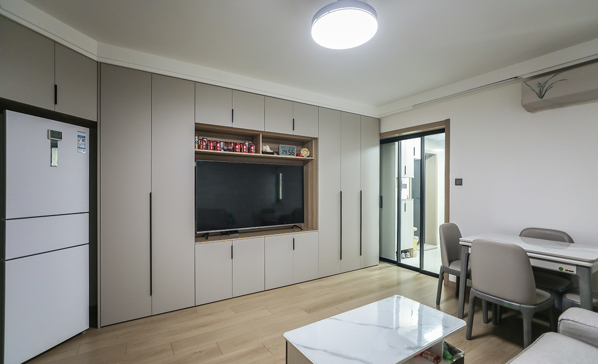 電視鏤空在電視柜中，儲物空間滿滿的，45度內嵌冰箱無縫銜接展示柜，沒有一絲浪費的精簡，讓空間不但時尚而且清爽。