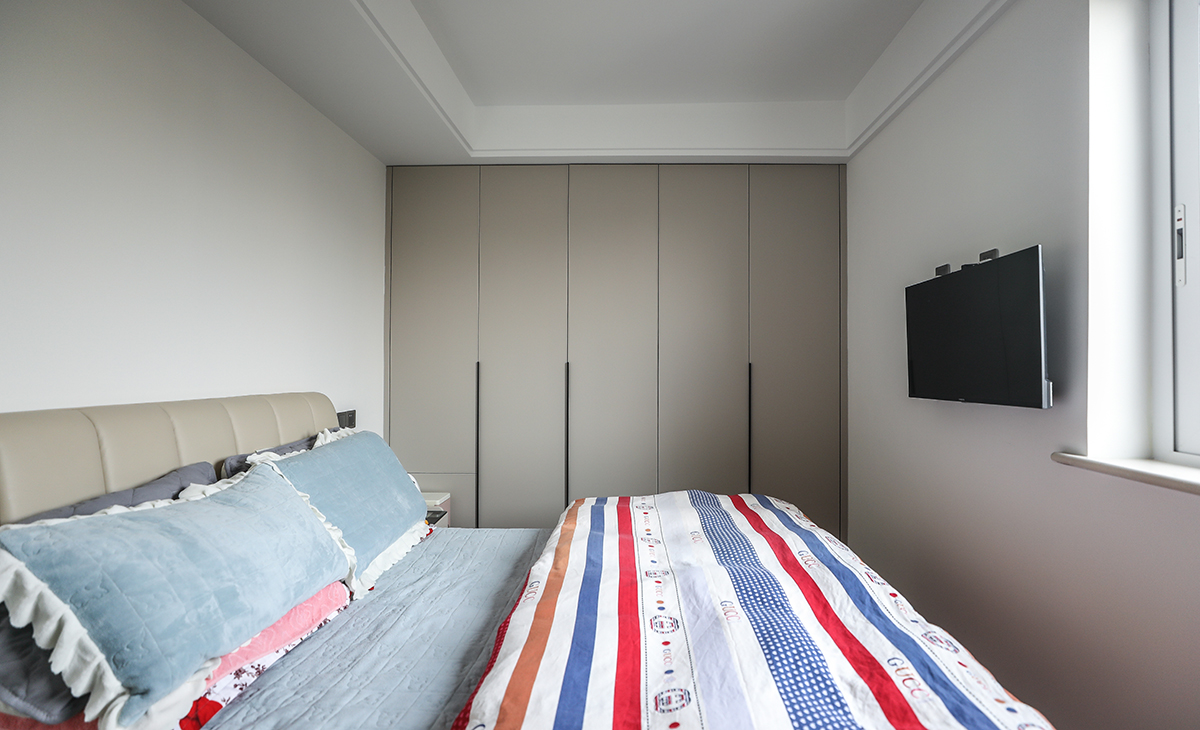 次臥小夫妻兩居住，靠床頭柜的柜門采用上下門，再也不會被床頭柜擋住而開不了門的情況了。地板原木色，墻面頂面白色乳膠漆，既簡單又實用。