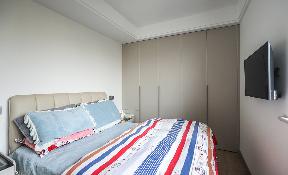 次臥小夫妻兩居住，靠床頭柜的柜門采用上下門，再也不會被床頭柜擋住而開不了門的情況了。地板原木色，墻面頂面白色乳膠漆，既簡單又實用。