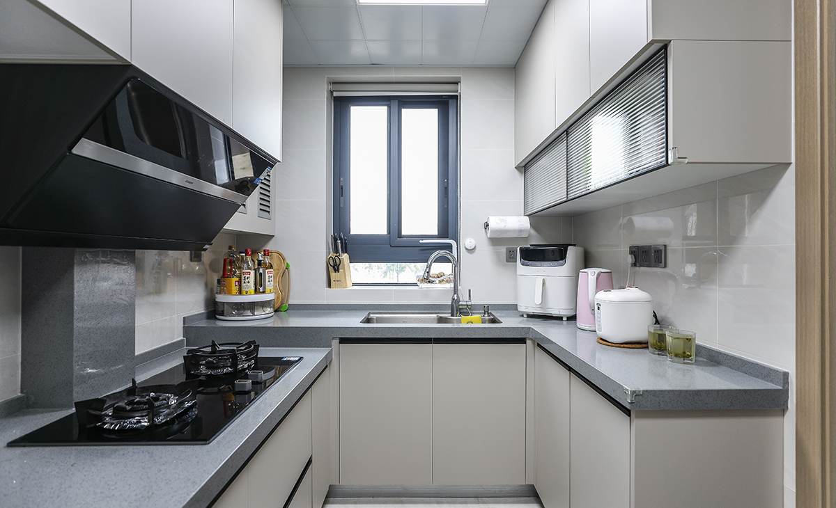 　　該套房子廚房空間很大，U型三面櫥柜，臺面錯層，洗碗再也不累腰。顏色簡潔明快，材質要干凈和好打理，白色的吊頂和米色的櫥柜相呼應，吊柜雙層儲物，調料罐罐都有地方可放。各種廚房電器全部配齊，滿足主人制作各種美食的需求。