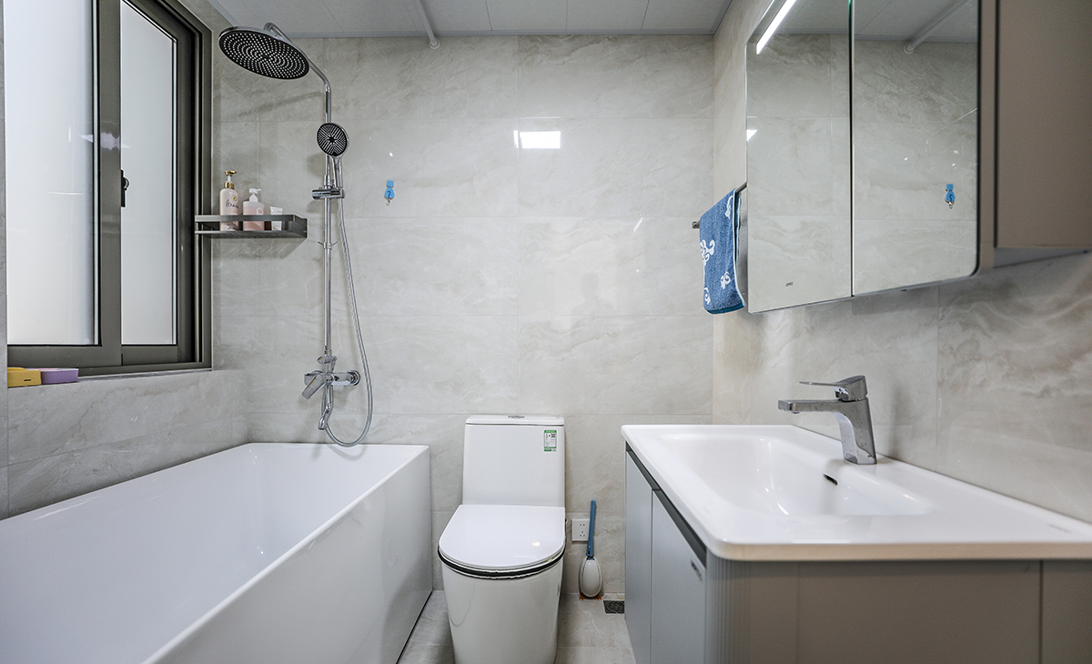 衛生間空間很大，放一個浴缸可以隨時隨地的泡澡，水質也干凈。地面暖灰色墻地磚，白色吊頂，鈦合金移門，配上馬桶和毛巾架，更加合理的衛浴空間。