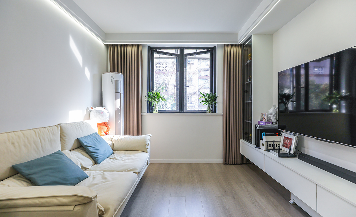 客廳空間整體以米灰色調(diào)為主，現(xiàn)代感軟裝與整體空間色調(diào)融為一體，半開放式上翻玻璃隔斷增加設計特點，更為客廳增加了光亮。