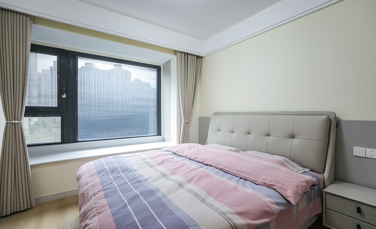 主臥奶黃色床頭背景，搭配墻板背景，奶咖窗簾+白色沙簾，造型以簡潔平板為主，方便打理，體現了北歐的溫馨、舒適，不拘一格。