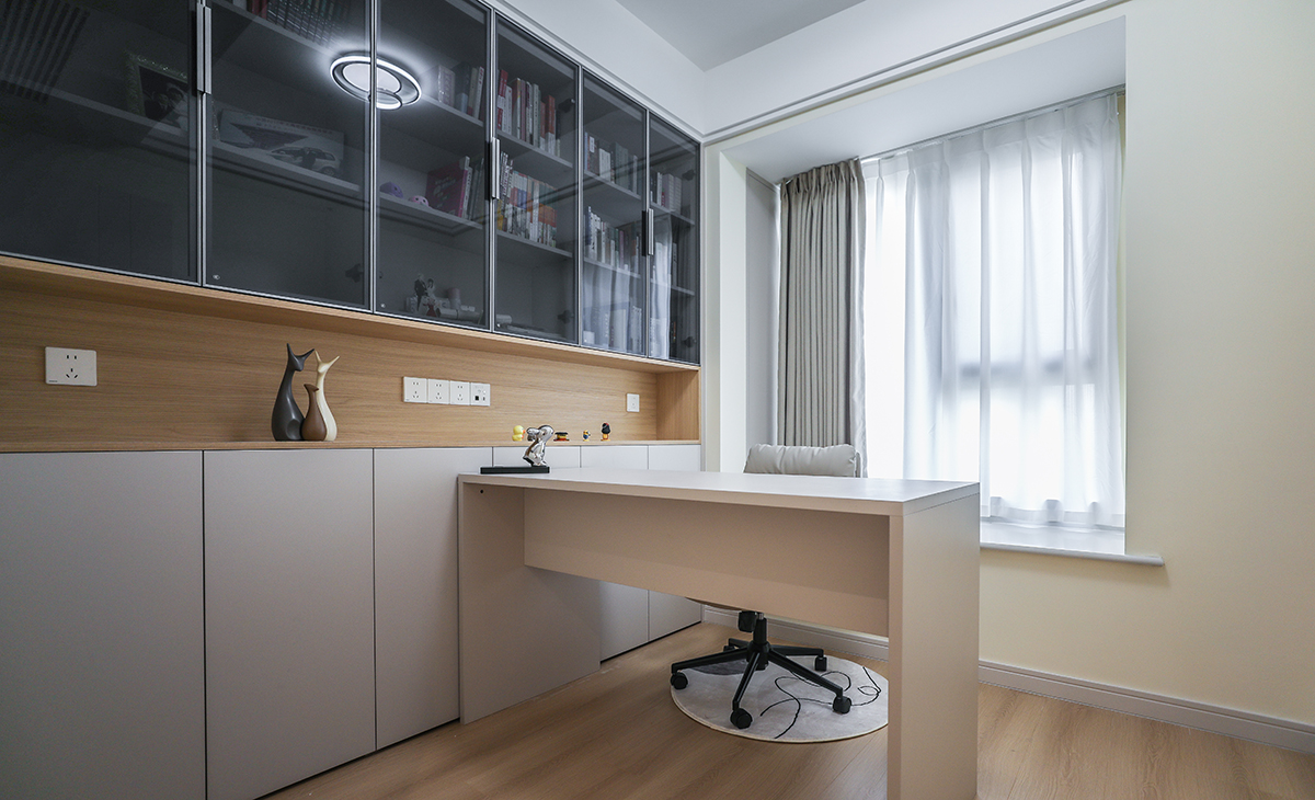 書房上面采用灰玻，中間鏤空放置打印機等小電器，可移動式書桌給整個空間增加了更多的活動可能性，閱讀累了坐在飄窗上喝喝茶看看風景。