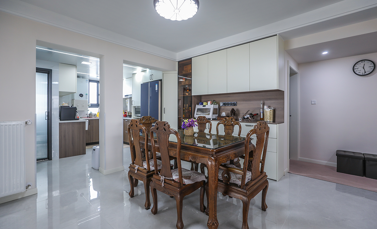 餐廳靠墻做一排裝飾柜，既實用、又有裝飾功能，極大的滿足了客戶的儲物多需求。深棕色框架與餐桌椅相呼應，淺灰色地磚很干凈，色彩和造型上都簡潔大氣。