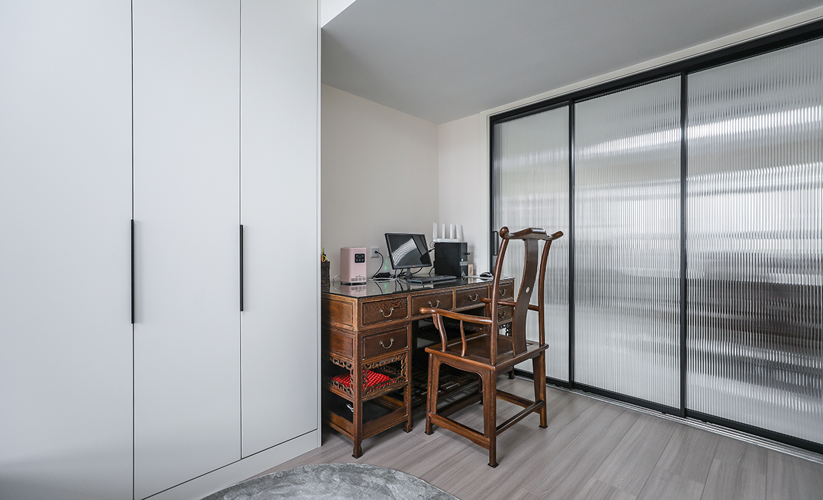 本套房子的小臥室儲物柜設計也是一大亮點，既實用，又有裝飾性，三門儲物柜，門板采用平板一門到頂，配備三聯動的長虹玻璃移門，給人感覺不僅雅致而且有韻味。