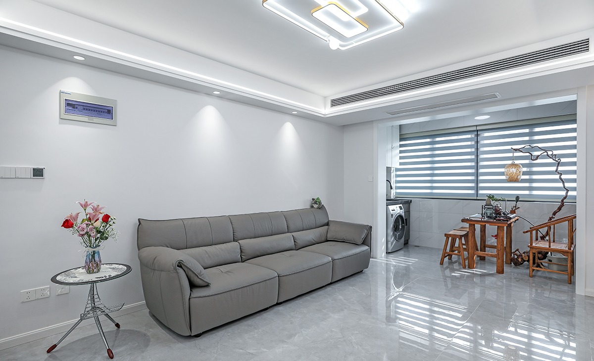 沙發背景刷米灰色涂料，頂面線型燈與射燈的搭配給沙發背景額外增加一絲風采，沙發用深色，深淺搭配的錯落有致，既溫馨又簡潔。