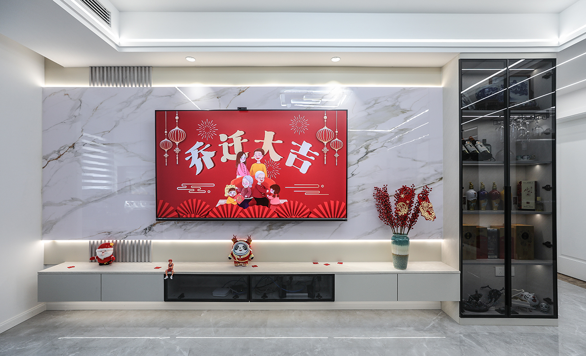 超大的巖板背景墻，頂上二個射燈點綴的恰到好處，加上木質格柵的搭配給整個背景墻增加一番優雅，電視邊柜采用透明黑色玻璃高端又大氣，電視柜也采用了懸空做法，讓空間不但時尚而且清爽。