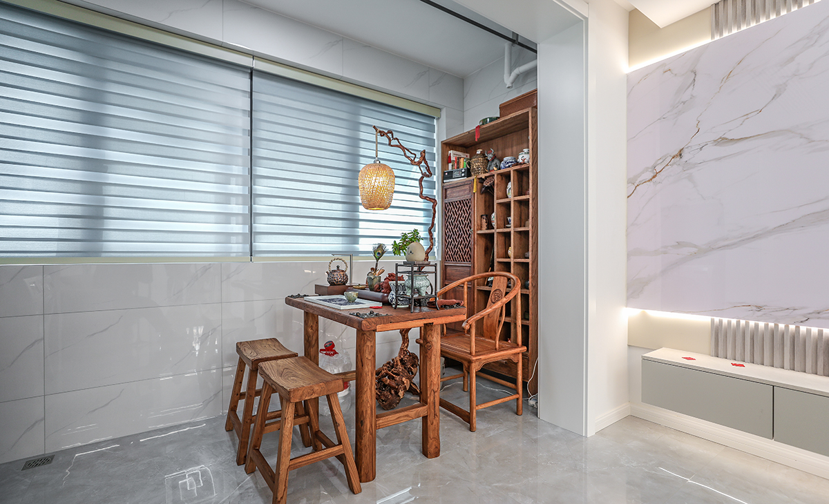 陽臺是晾曬衣物的場所，一側洗衣機和水池，一側為喝茶區，顏色以原木為主，彰顯主人生活品味，超大玻璃窗讓陽光柔和的照進來，很舒適、很愜意。