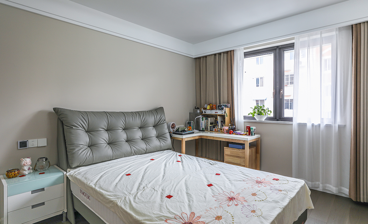  次臥為女兒房間，采用一個床頭柜做法，靠窗做轉角書桌，空間利用和功能性俱全，墻面刷奶咖色墻面乳膠漆，頂面白色乳膠漆，既簡單又實用。