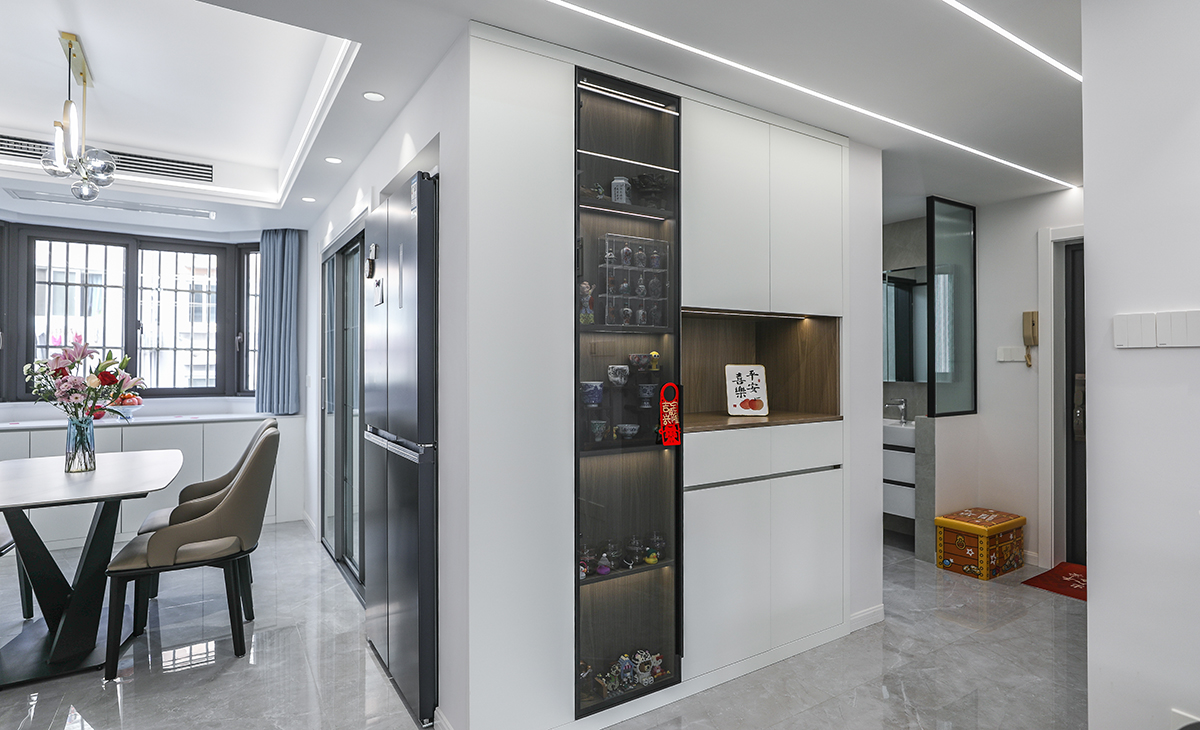 本套房子的走道儲物柜設計也是一大亮點，既實用，又有裝飾性，雙門儲物柜，留一門做玻璃門板，展示主人收藏的藝術品，門板采用平板一門到頂，和臥室門顏色相統一，給人感覺不僅雅致而且有韻味。