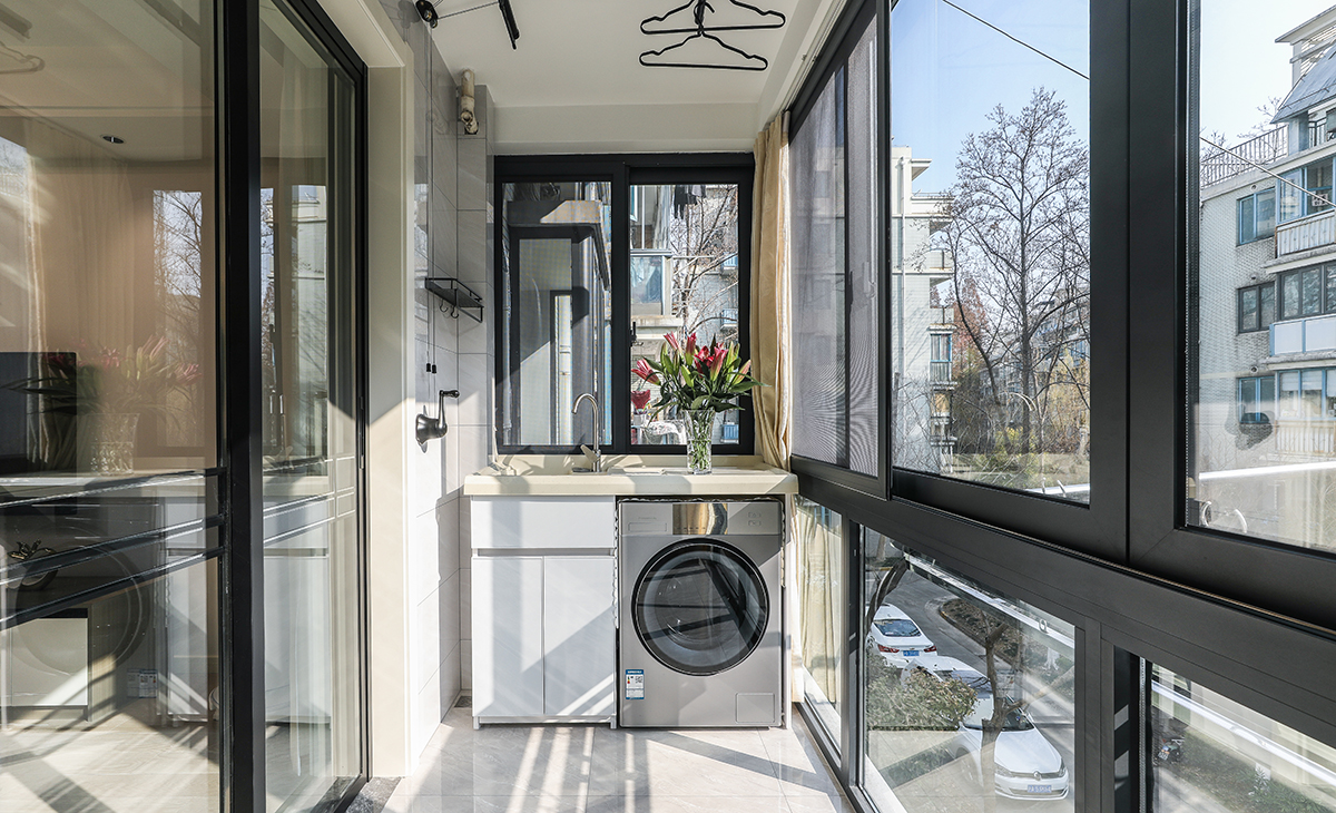 陽臺是晾曬衣物的場所，一側洗衣機和水池，顏色以白色為主，和門套相配