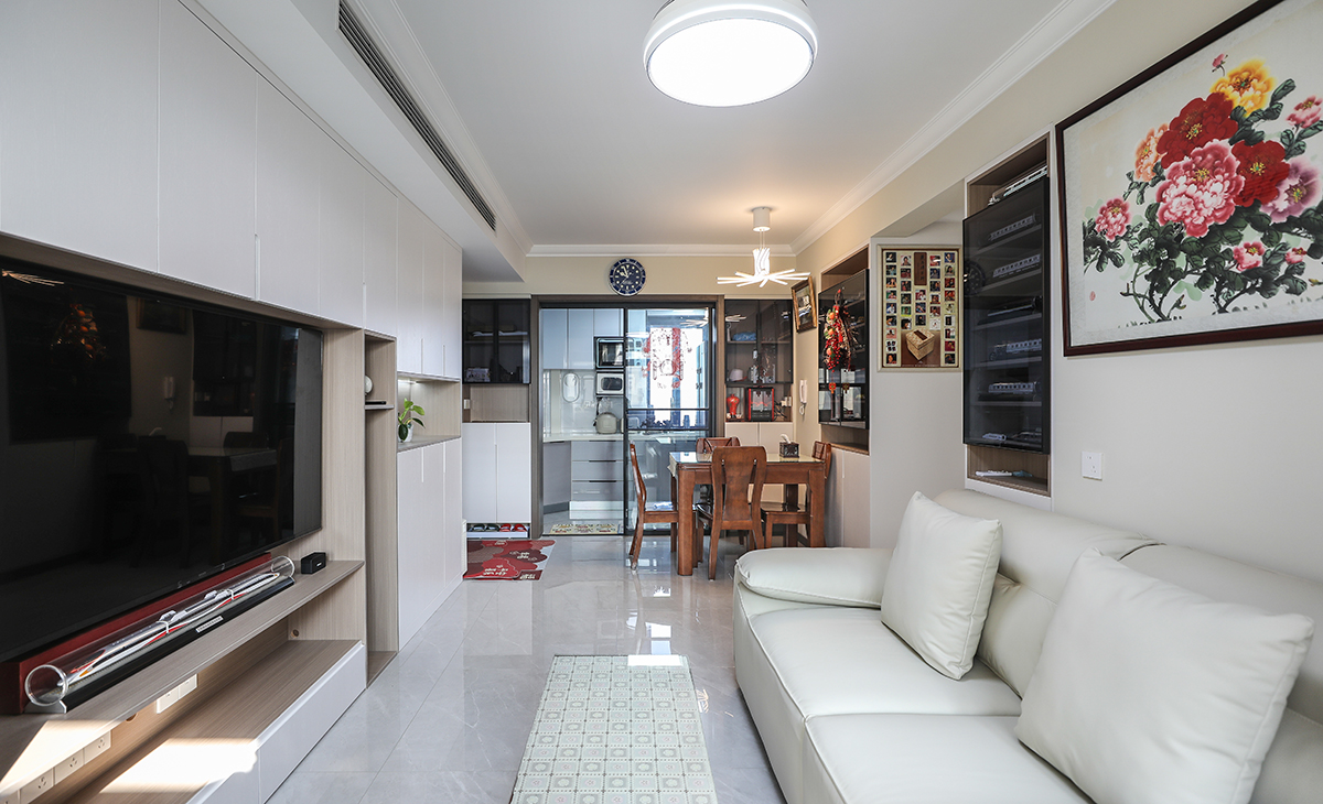 客廳面積不大，但經(jīng)過設(shè)計(jì)師的手筆，讓空間緊湊不擁擠，電視墻做純色乳膠漆，和沙發(fā)背景淺灰色相互配合，明暗有神，深灰色皮質(zhì)沙發(fā)立刻檔次提高很多。吊頂造型上采用簡單的石膏線，讓造型柔和很多。地面采用淺灰色地磚。造型和色調(diào)上無不給人以簡潔、大氣、時(shí)尚的感覺。