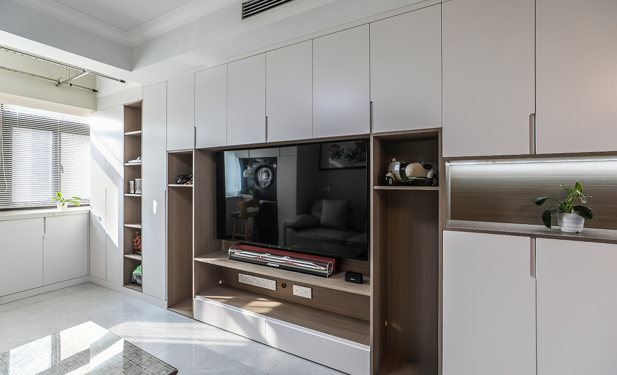 進(jìn)戶鞋柜與電視柜整體做成一體式的柜體，設(shè)計(jì)采用下方和中間漏空，下方放鞋，中間放工藝品，讓鞋柜功能齊全，顏色和防盜門、進(jìn)戶門套能夠協(xié)調(diào)。