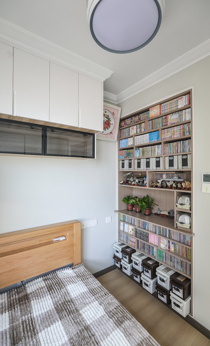 次臥是男主人居住，需要放置大量的CD，利用與主臥之間的非承重墻體做出儲(chǔ)藏空間，讓6個(gè)平方的次臥空間很寬敞，感覺不到擁擠，顏色深淺有序，很溫馨，舒適、給人感覺不僅雅致而且有韻味。