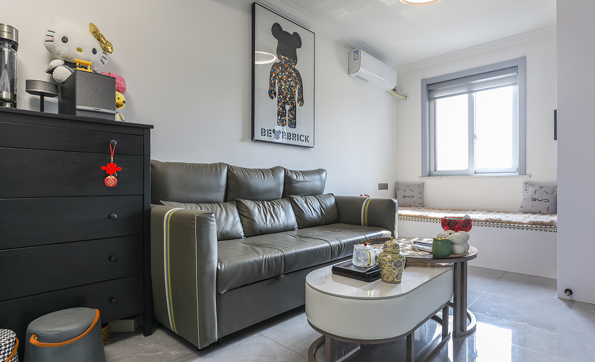 沙發用了皮質沙發，沙發背景留白設計，色調上墻面涂料用淺色，沙發用深色，深淺搭配的錯落有致，既溫馨又簡潔。