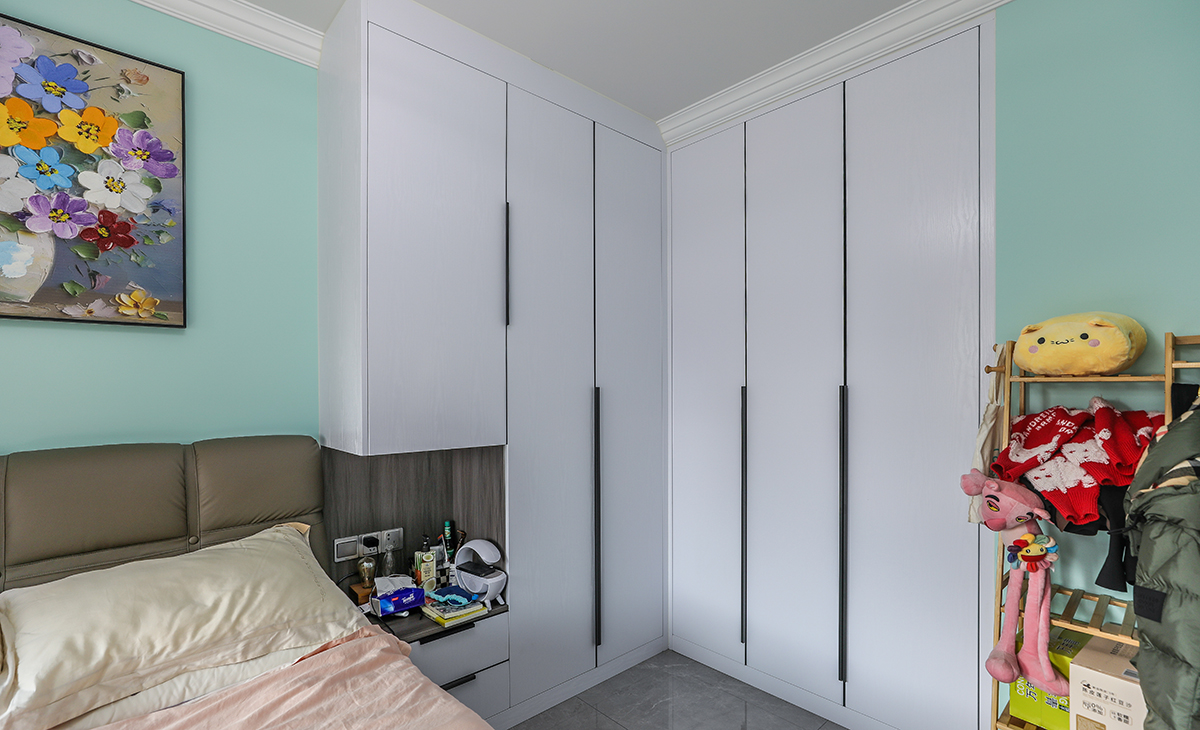 主臥采用L型柜子，讓整個空間放大，墻面刷淺綠色墻面乳膠漆，頂面白色乳膠漆，既簡單又實用。