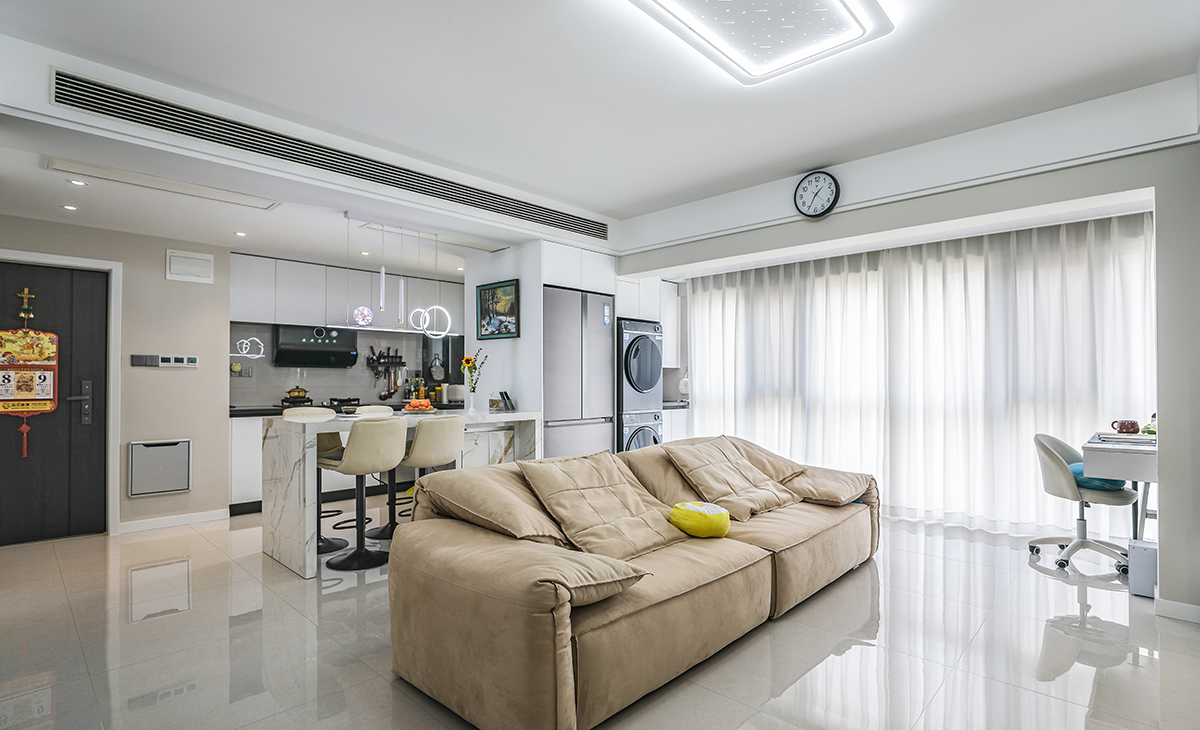 客廳面積不大，但經(jīng)過設(shè)計師的手筆，采用了開放式廚房和客廳陽臺無縫銜接的設(shè)計，最大程度增加了房子的空間感。吊頂造型上采用時尚簡約的平頂雙眼皮吊頂設(shè)計，結(jié)合中央空調(diào)，讓造型更顯清爽，地面采用淺灰色地磚。造型和色調(diào)上無不給人以簡潔、大氣、時尚的感覺。