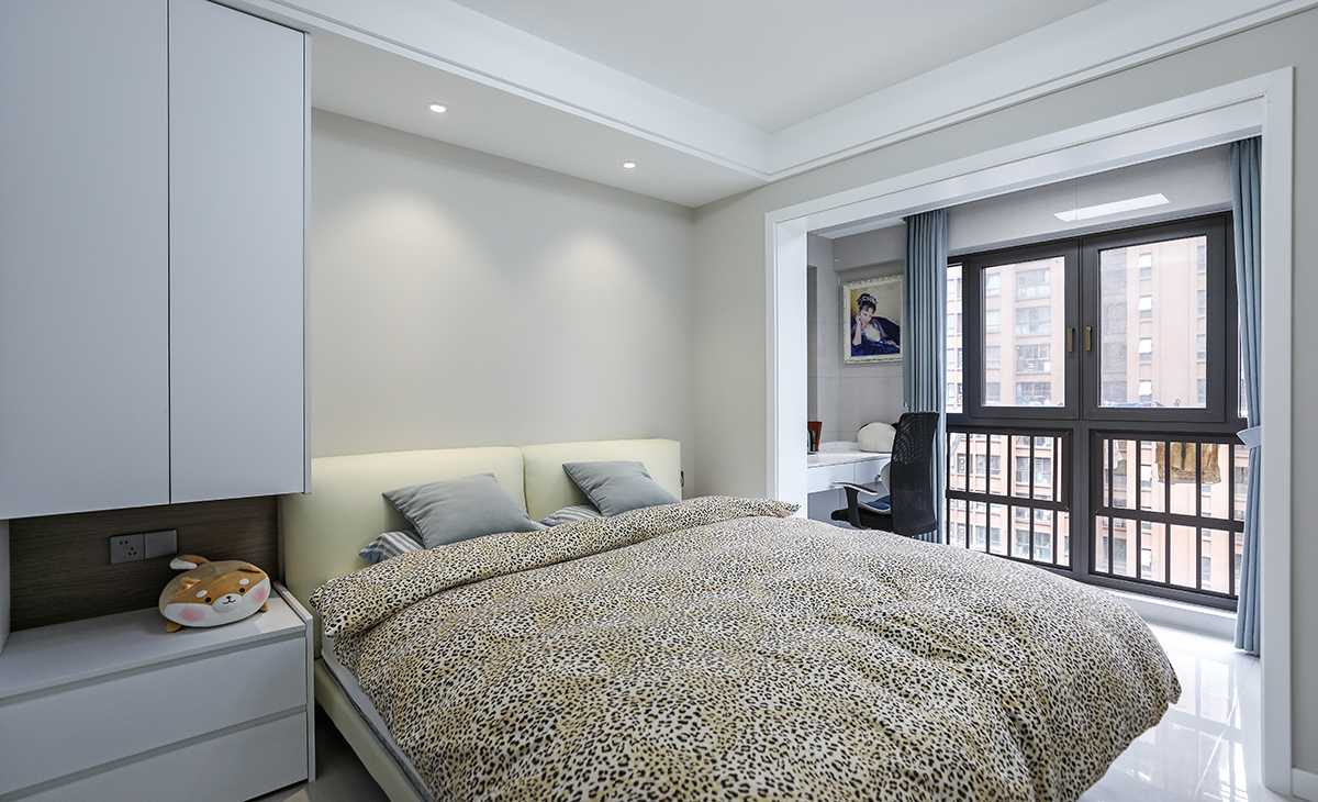 主臥奶咖色墻面，配白色衣柜，搭配灰藍色窗簾造型以簡潔為主，方便打理，體現(xiàn)了簡約風(fēng)格的簡潔、隨意，不拘一格。