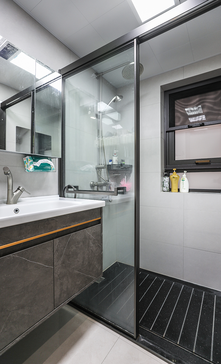 衛(wèi)生間不大，但很緊湊，槍灰色的淋浴房、龍頭、花灑，墻地一體的瓷磚、白色的集成吊頂，淋浴房內(nèi)黑色天然大理石防滑地面，無不體現(xiàn)主人高檔次的生活品味和優(yōu)雅的審美觀。
