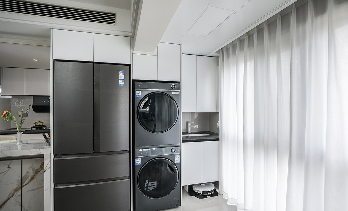 陽臺雖然和客廳融為一體，但它也有效的發(fā)揮了它改有的功能，洗衣機、烘干機、洗衣池、掃地機器人包括收納柜都給安排的妥妥的。