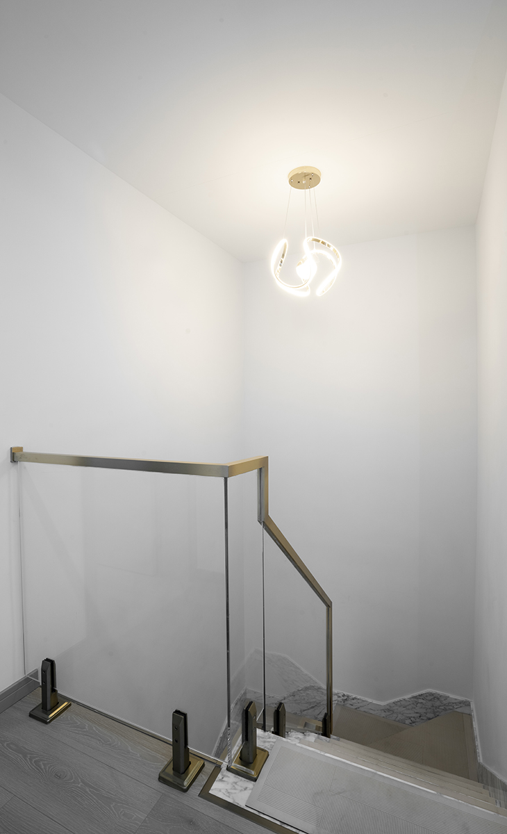 該套房子樓梯間設(shè)計的效果圖很通透自然，古銅色不銹鋼扶手+鋼化玻璃欄桿，光線很好，頂面藝術(shù)吊燈，把空間襯托的完美無霞。樓梯下方的空間可供儲物。
　　