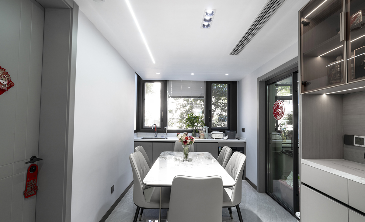 餐廳空間方正大氣、米色餐椅，白色巖板餐桌，餐邊柜帶層板線燈，另有一組西廚，方便清洗水果，體現(xiàn)了主人隨意、自由的個性。