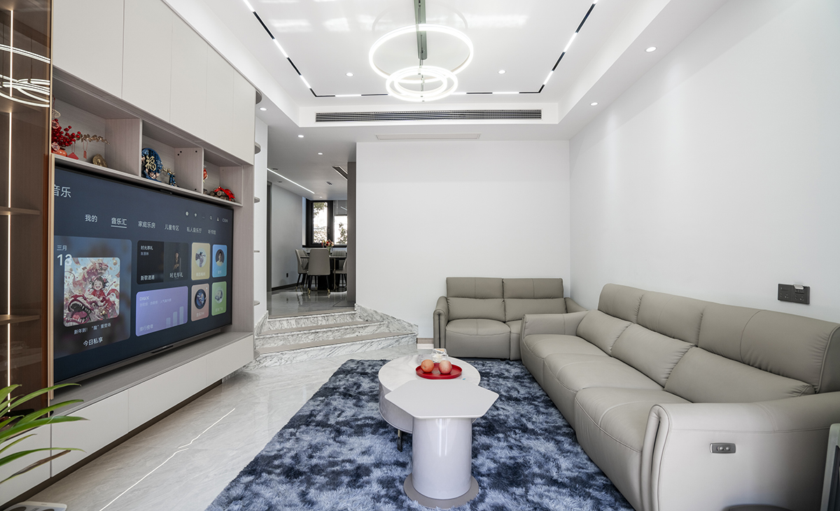 客廳是接待客人的空間、是家庭裝修的亮點所在、也是一家人活動頻率最高的區(qū)域，米色皮質(zhì)沙發(fā)，體現(xiàn)穩(wěn)重大氣，吊頂造型上采用方形石膏板+四周磁吸軌道燈，時尚氣息很濃。地磚采用淺灰色600*1200大地磚，電視柜和組合柜都是懸空，方便清潔。造型和色調(diào)上無不給人以簡潔、大氣、時尚的感覺。