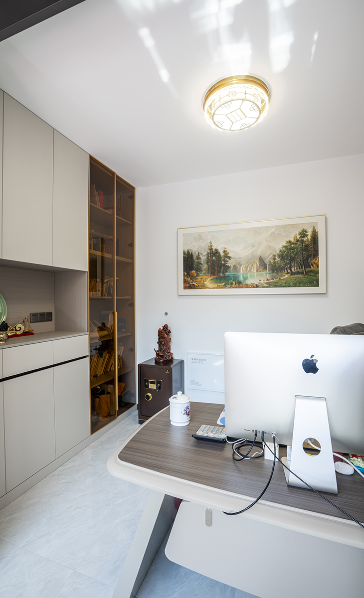 書房布置的井然有序，老板椅背面掛一幅山水畫，側(cè)面一組玻璃門的書柜。把整面墻點綴地恰到好處，顯得既活潑又時尚，深色原木工作臺、黑色老板椅體現(xiàn)主人的穩(wěn)重，踏實。