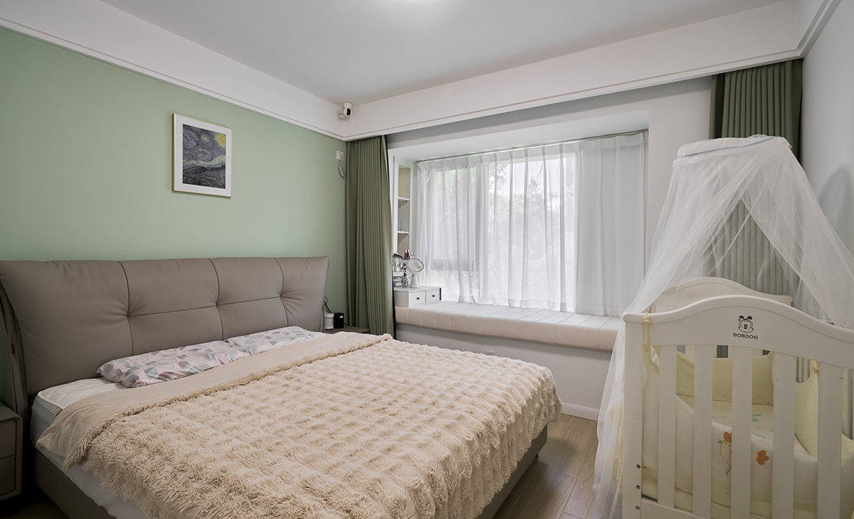 　　主臥床頭背景綠色，地面用胡桃色，L型大飄窗讓臥室空間具有延伸感，射燈把整個空間點綴地豐富、有質感