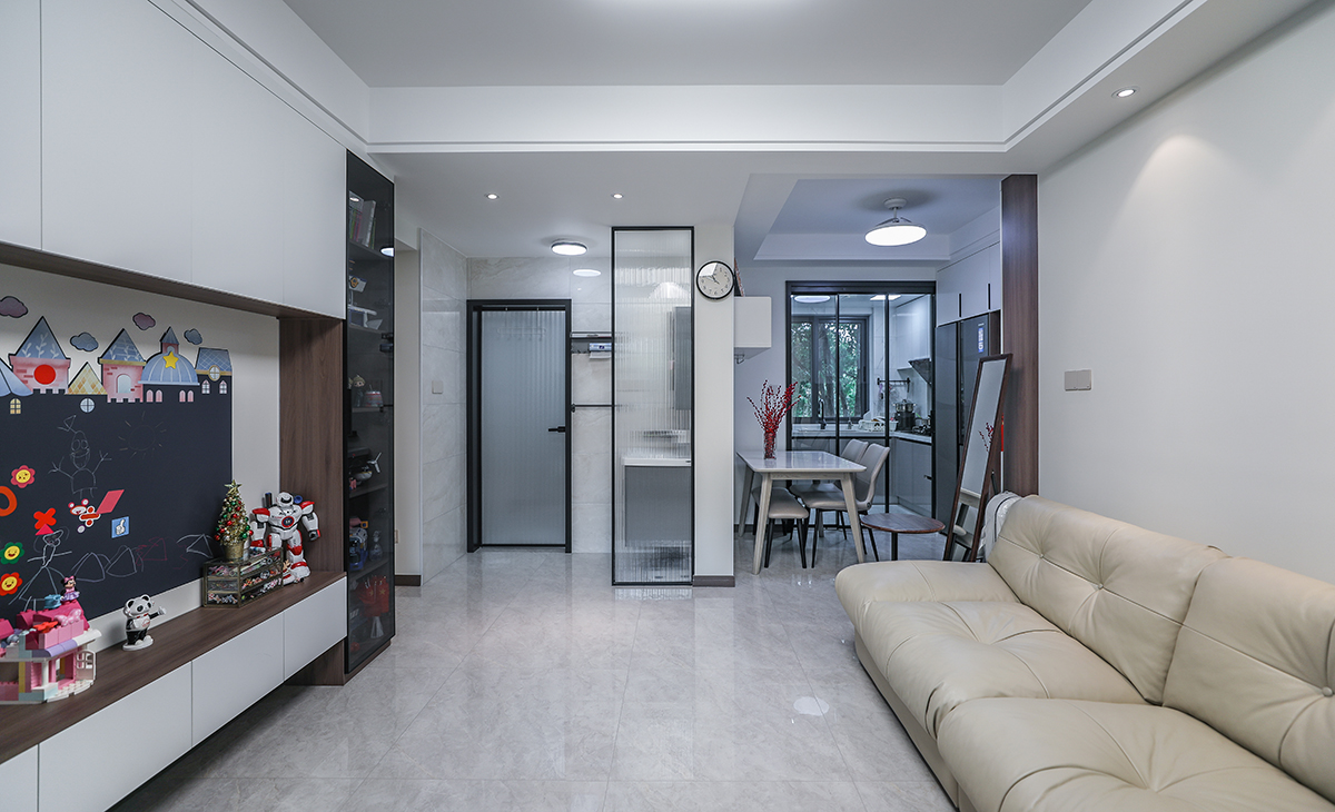 餐廳空間比較方正寬敞，聯通廚房的位置做三聯動推拉移門，放大了空間感，靠墻做嵌入式冰箱，既實用、又有裝飾功能，原木色框架和白色木門板相呼應，巖板餐桌把用餐氛圍調和的很溫暖，淺灰色地磚很干凈，色彩和造型上都簡潔大氣。