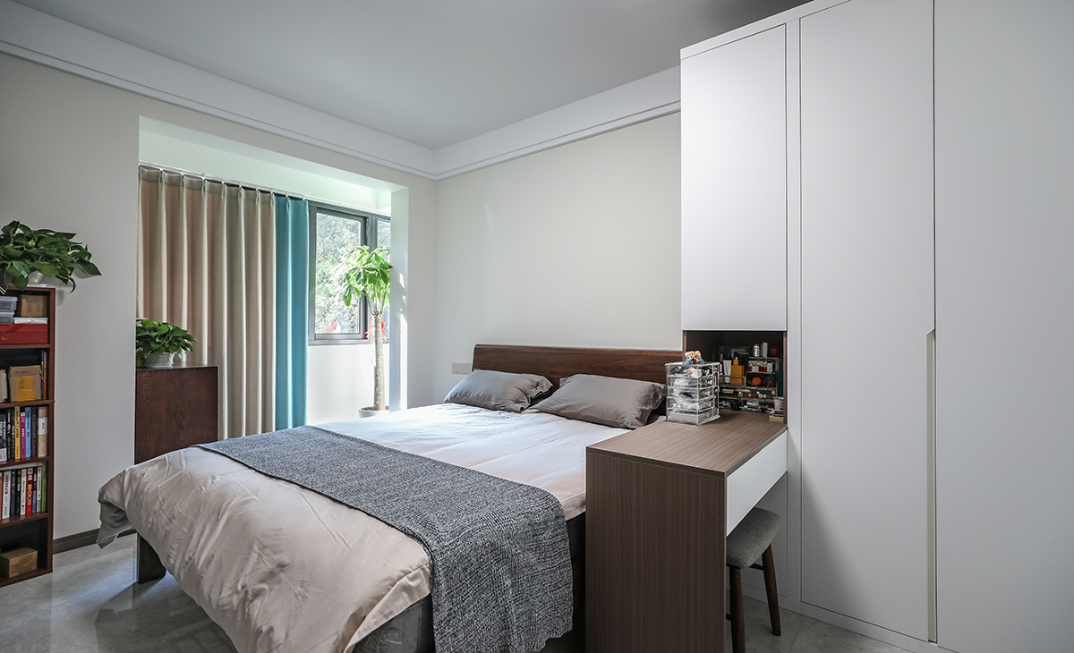 主臥整體瓷磚通鋪，所以床選擇的是深色，和衣柜的木飾面顏色統一，這樣和整體的色彩搭配就非常的協調，雙眼皮石膏板走一圈，簡潔大氣，方便打理，體現了簡約風格的簡潔、隨意，不拘一格。