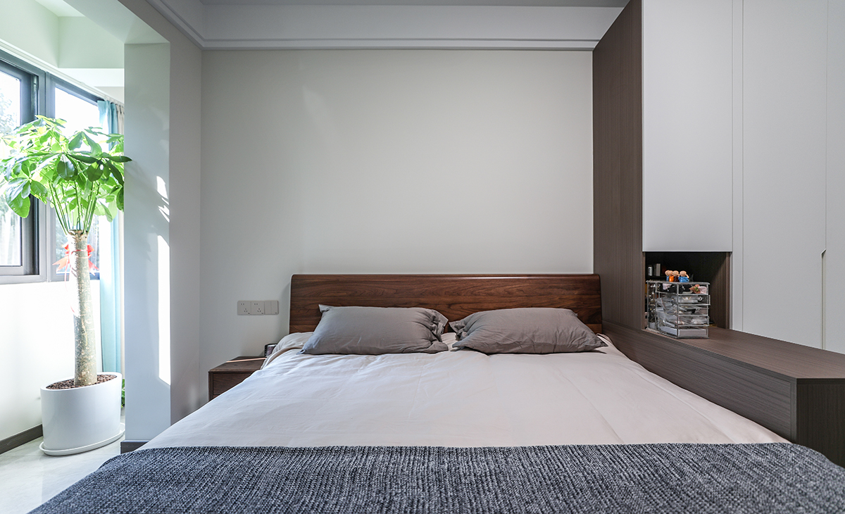 主臥整體瓷磚通鋪，所以床選擇的是深色，和衣柜的木飾面顏色統一，這樣和整體的色彩搭配就非常的協調，雙眼皮石膏板走一圈，簡潔大氣，方便打理，體現了簡約風格的簡潔、隨意，不拘一格。