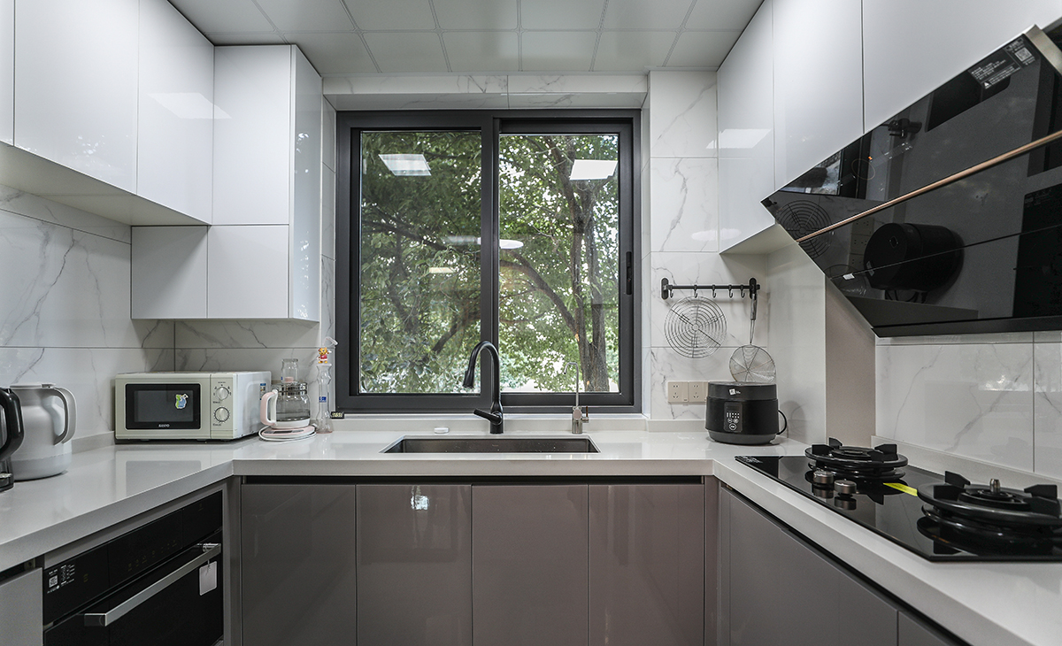 　該套房子廚房空間很大，U型臺面三面櫥柜，兩面吊柜，滿足了儲物功能，又不遮擋視線，顏色簡潔明快，材質要干凈和好打理，白色的吊頂和米色的櫥柜相呼應，石英石臺面經久耐用，各種廚房電器全部配齊，滿足主人制作各種美食的需求。