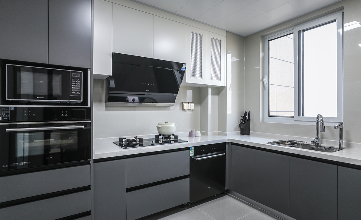 該套房子廚房空間很大，L型兩面櫥柜，另外冰箱邊上也有操作臺(tái)，顏色簡(jiǎn)潔明快，材質(zhì)要干凈和好打理，白色的吊頂和米色的櫥柜相呼應(yīng)，不銹鋼臺(tái)面經(jīng)久耐用，各種廚房電器全部配齊，滿(mǎn)足主人制作各種美食的需求。