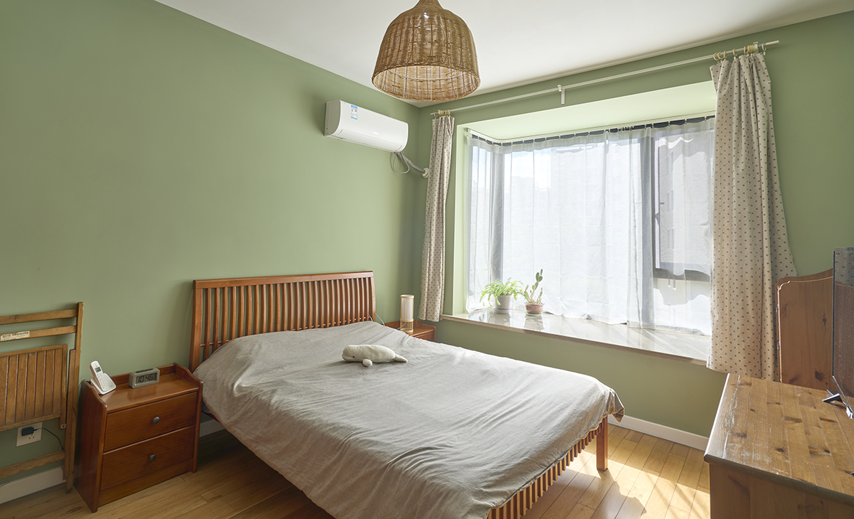 主臥床頭背景綠色，地面用胡桃色，L型大飄窗讓臥室空間具有延伸感，射燈把整個空間點綴地豐富、有質(zhì)感