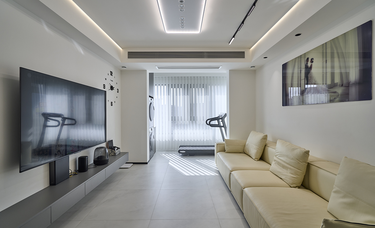 客廳是接待客人的空間、是家庭裝修的亮點所在、也是一家人活動頻率最高的區域，米色皮質沙發，體現高端華貴，吊頂造型上采用方形石膏板+成品石膏線燈帶，黑色電視機和電視柜相呼應。地面采用灰色柔光地磚，沙發背景采用裝飾掛畫。造型和色調上無不給人簡潔、高雅、溫馨的氣息。