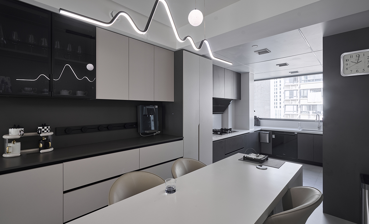 餐廳空間比較方正，整面餐邊柜和餐桌顏色呼應，配以黑色極窄邊框玻璃門，若隱若現，很夢幻、頂面曲線吊燈是一大亮點，把空間點綴地恰到好處。