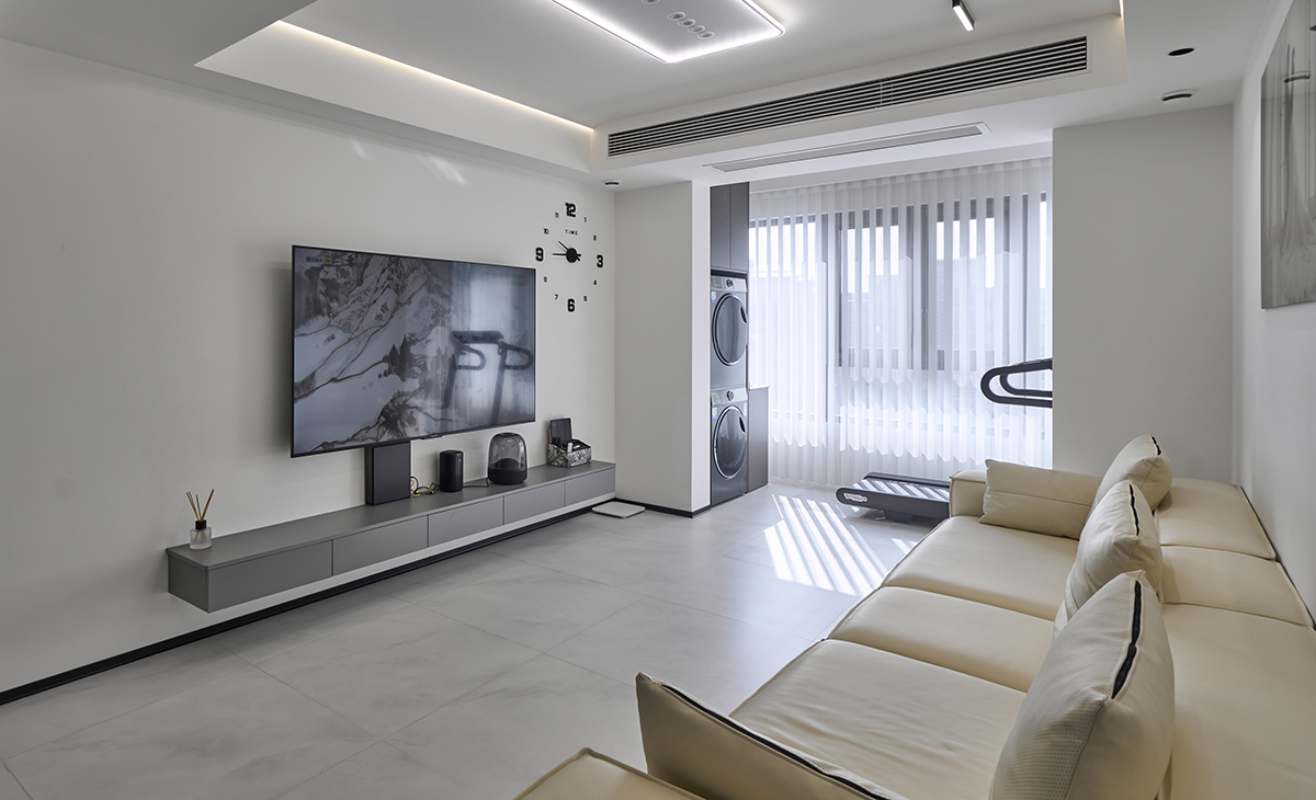 客廳采用去茶幾化設計，體現現代極簡風格的簡潔時尚，空間方正大氣、電視背景采用白色墻+時鐘掛畫設計，讓空間不單調。