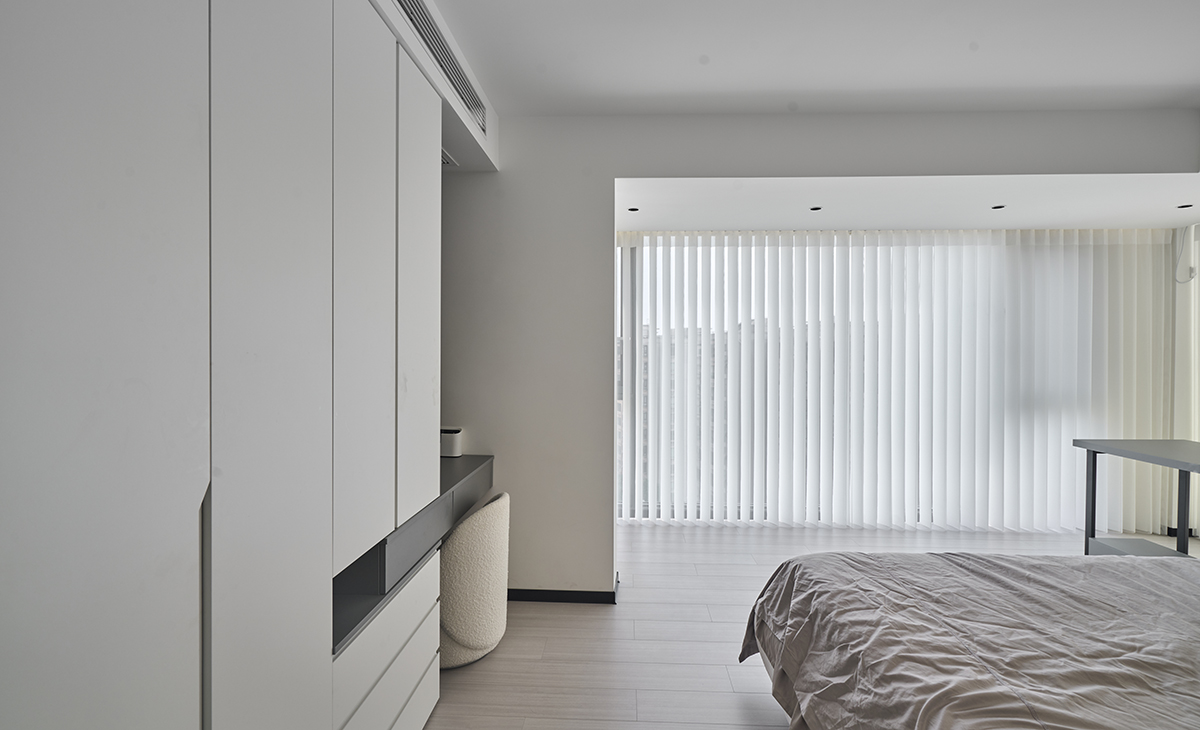 主臥和東陽臺打通，空間很大，三面窗，視線很寬廣，書桌和梳妝臺，衣柜展示柜都很大，儲物空間很多，灰色床單、灰色地板，淺灰色的柜子，讓整個空間明亮和增大很多。