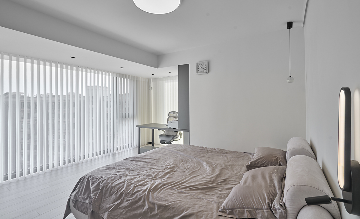 主臥和東陽臺打通，空間很大，三面窗，視線很寬廣，書桌和梳妝臺，衣柜展示柜都很大，儲物空間很多，灰色床單、灰色地板，淺灰色的柜子，讓整個空間明亮和增大很多。