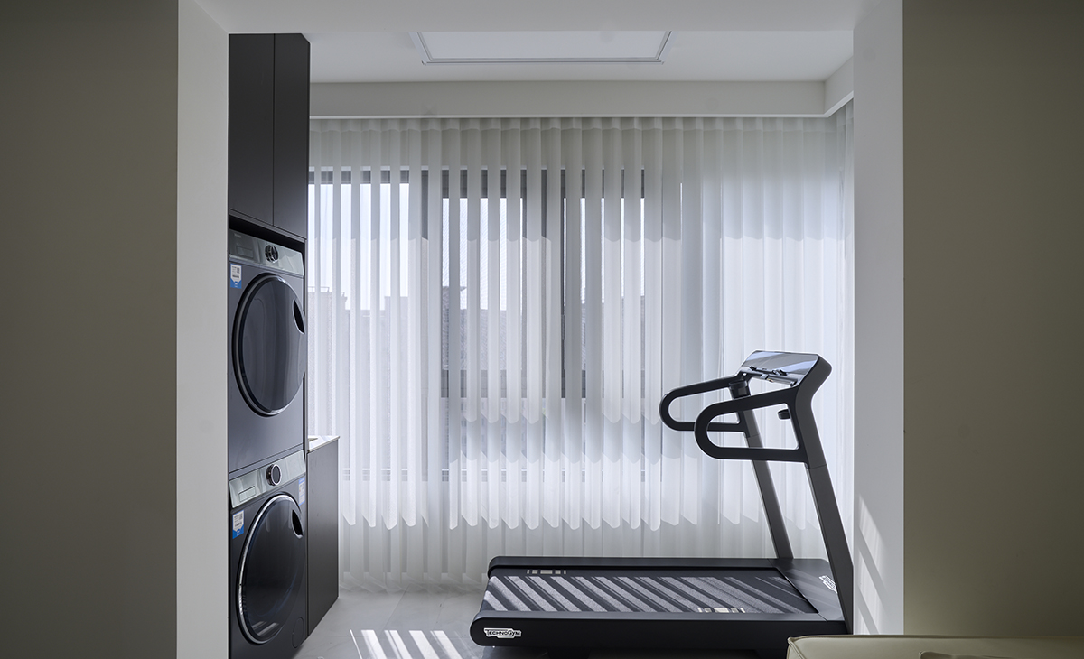 該套房子陽臺的空間利用的很完美，洗衣機對面放一個跑步機，方便主人健身。