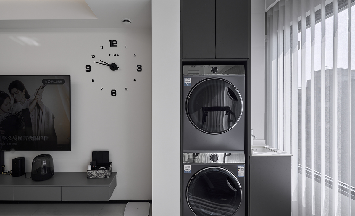 陽臺一邊放洗衣機、烘干機上方有吊柜，旁邊還能放一個小水池，方便主人洗溯，白色紗簾，讓陽光照進來很柔和。
