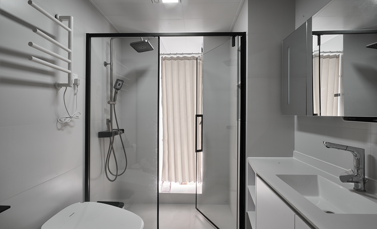 客衛柔光淺灰色墻地磚，黑色邊框淋浴房，白色浴室柜、抽拉龍頭，智能馬桶，體現了客戶的高檔生活品質。